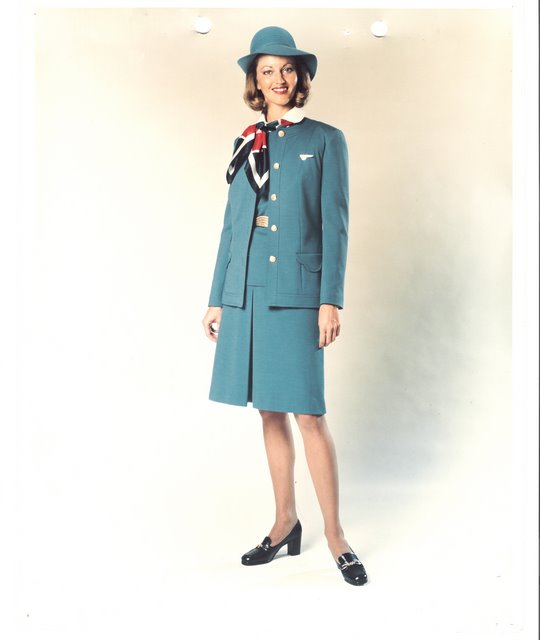 1970s Flight Attendant Judy Skartvedt poses in a uniform designed by Edith Head.  This uniform was available to flight attendants in navy & Pan Am blue.